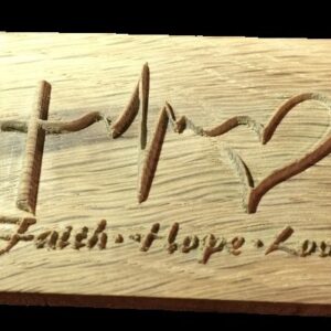 A wooden plaque with the word faith, hope and love engraved on it.