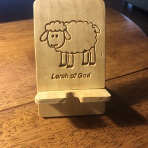 A wooden phone holder with an image of a sheep.