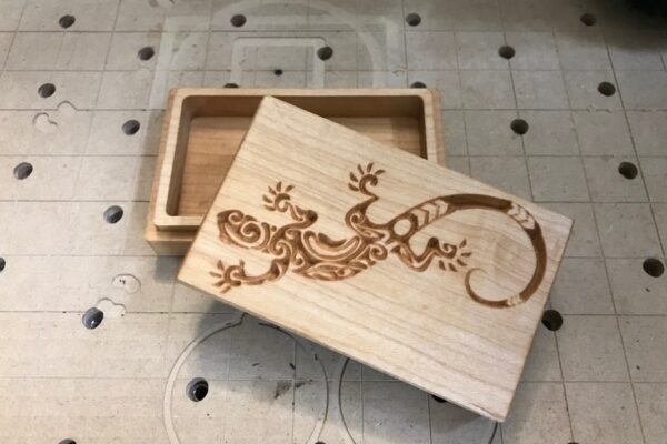 A wooden box with an image of a lizard on it.