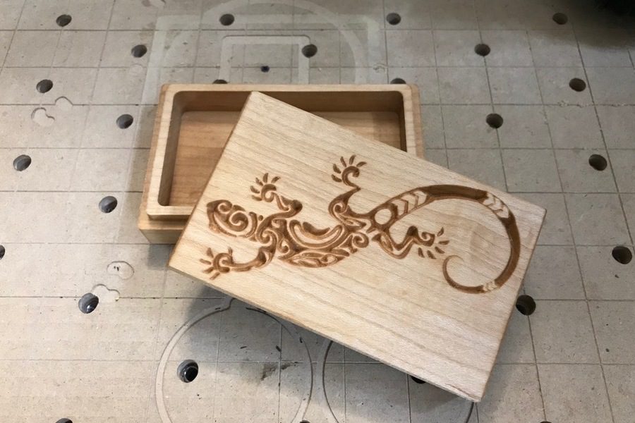 A wooden box with an image of a lizard on it.